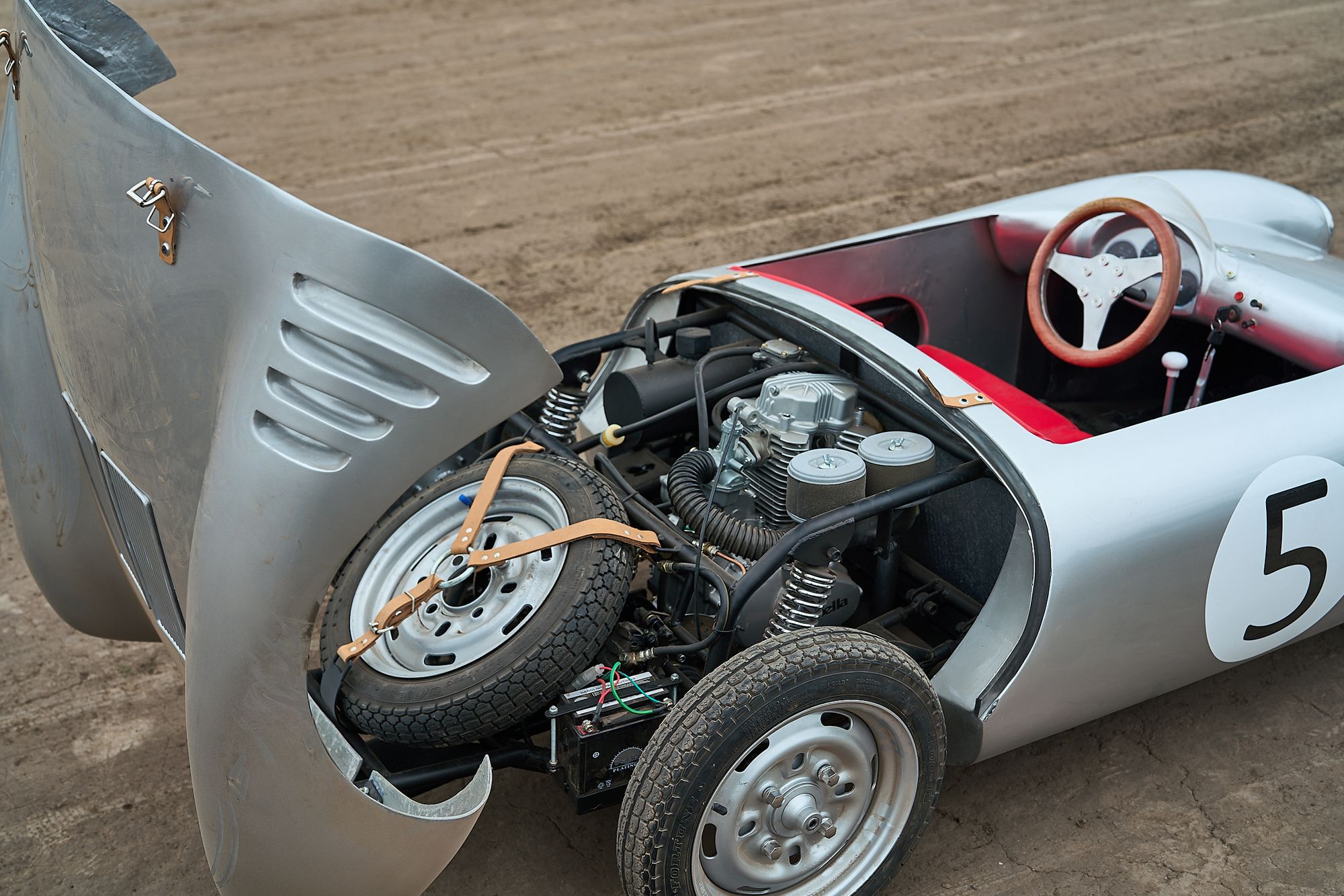 Open engine bay of the Rähle tribute car showing the 110cc engine and tubular chassis