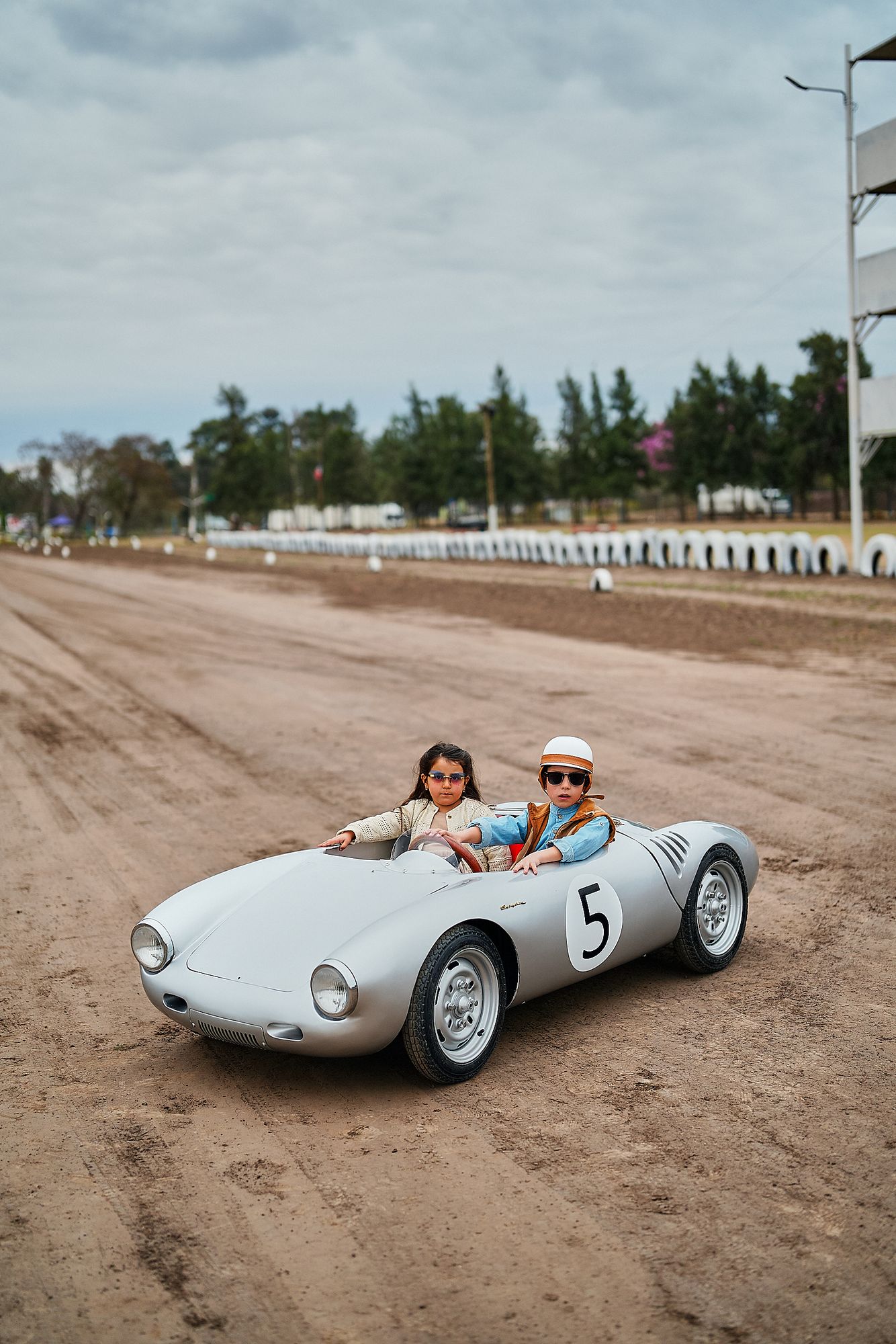 Two children driving the Rähle tribute car on a dirt track