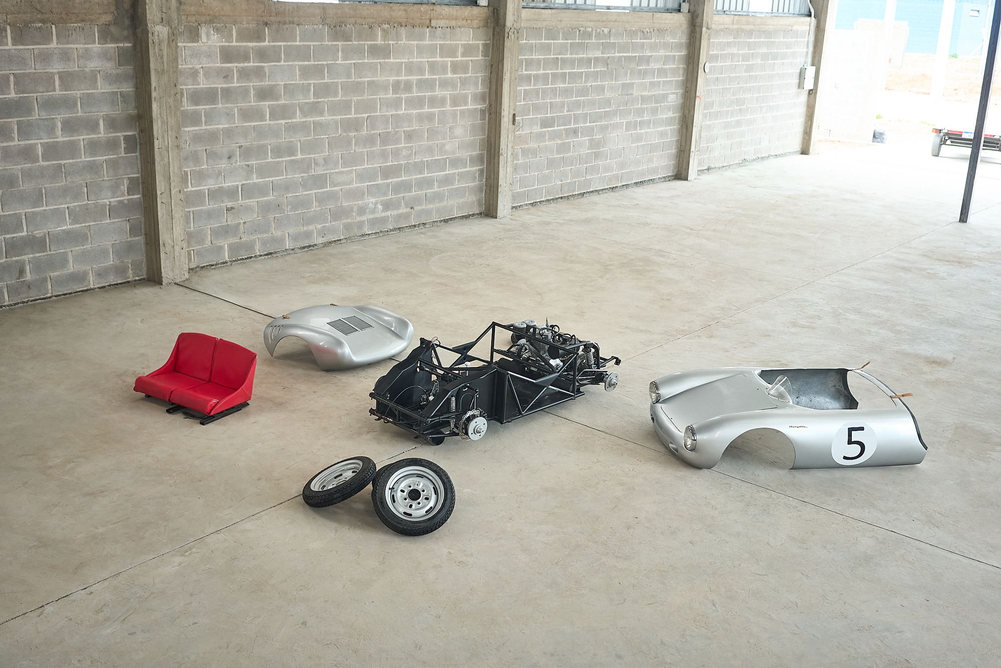 The Rähle tribute car's body, chassis, seats, and wheels laid out separately before assembly