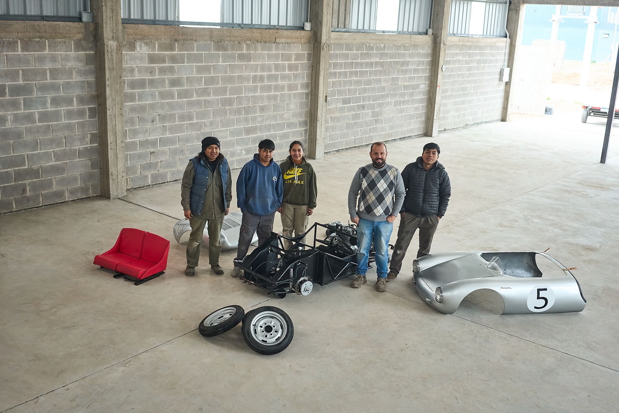 The Rähle build team standing with the disassembled tribute car in the Argentina workshop